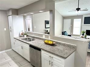 kitchen with dishwasher, kitchen peninsula, white cabinetry, and light stone counters