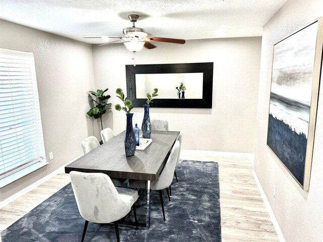 dining space featuring a textured ceiling, hardwood / wood-style flooring, and ceiling fan