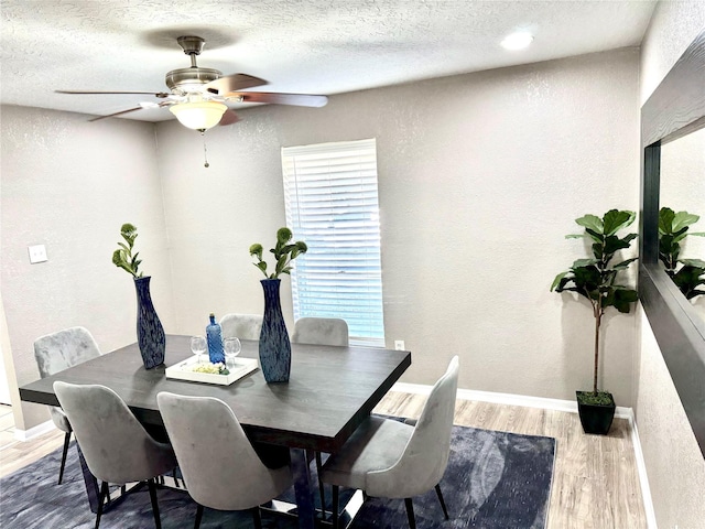 dining room with hardwood / wood-style floors, a textured ceiling, and ceiling fan