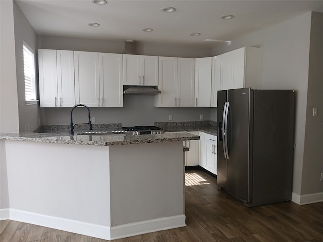 kitchen with dark stone countertops, stainless steel fridge with ice dispenser, white cabinets, and dark hardwood / wood-style floors