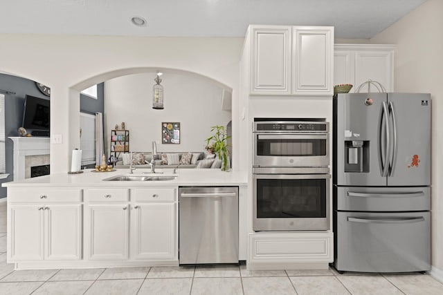 kitchen featuring white cabinets, appliances with stainless steel finishes, light tile patterned floors, and sink