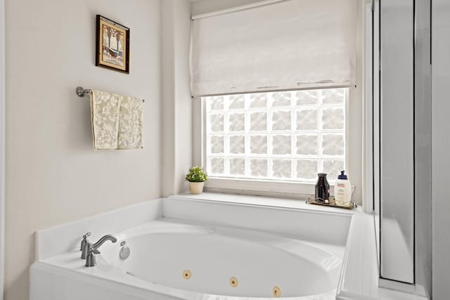 bathroom with a relaxing tiled tub