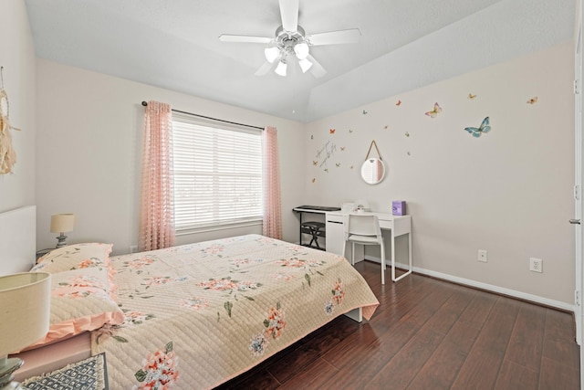 bedroom with a raised ceiling, ceiling fan, and dark hardwood / wood-style floors