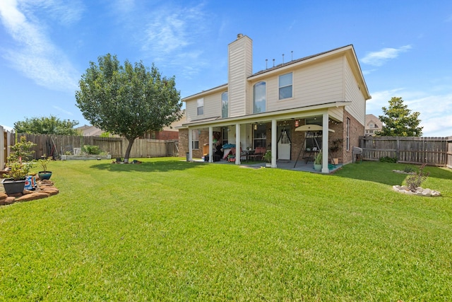 back of house with a lawn and a patio area