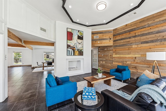 living room featuring a barn door, wood walls, and ornamental molding