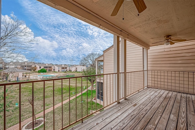 wooden deck featuring a lawn and ceiling fan