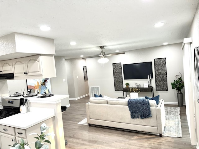 living room with light wood-type flooring and ceiling fan