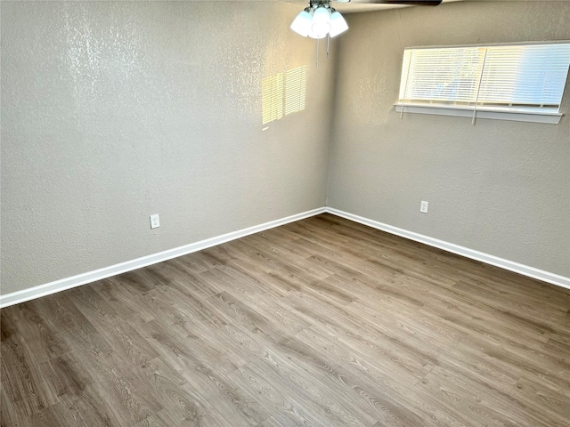 empty room with ceiling fan and light hardwood / wood-style flooring