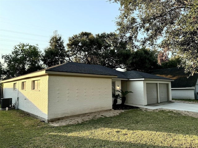 garage featuring a lawn and central AC