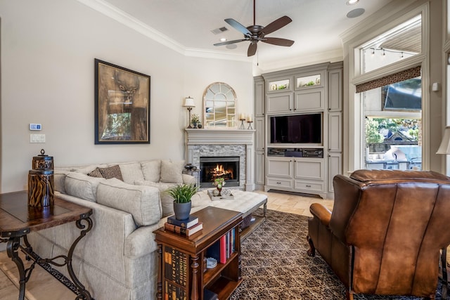 living room featuring ornamental molding, ceiling fan, and a fireplace