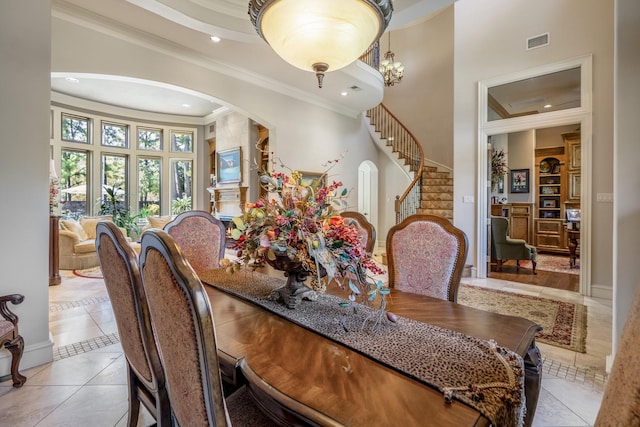 dining area featuring a high ceiling, light tile patterned flooring, and ornamental molding