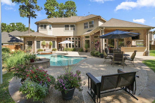 view of swimming pool featuring an in ground hot tub, exterior bar, exterior kitchen, and a patio