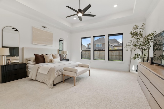 bedroom featuring a tray ceiling, ceiling fan, and light colored carpet