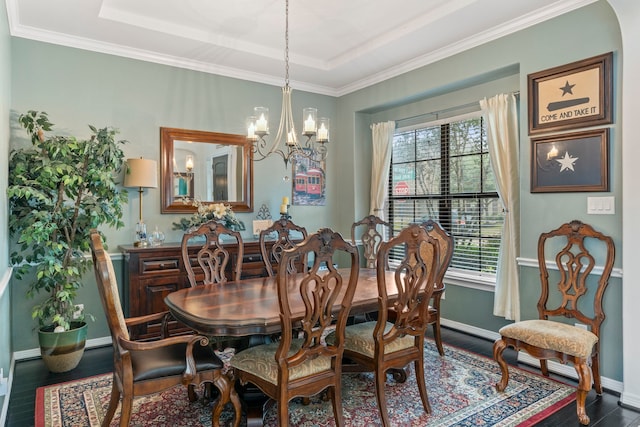 dining area featuring a notable chandelier, dark hardwood / wood-style floors, a wealth of natural light, and a tray ceiling