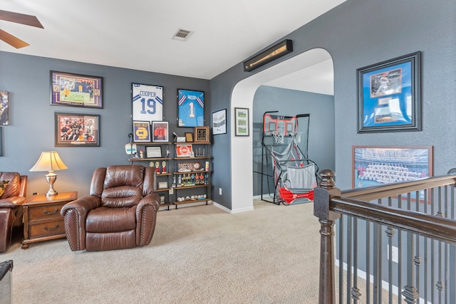 interior space featuring carpet flooring, a crib, and ceiling fan