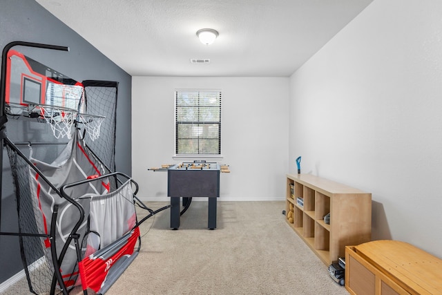 recreation room featuring carpet and a textured ceiling