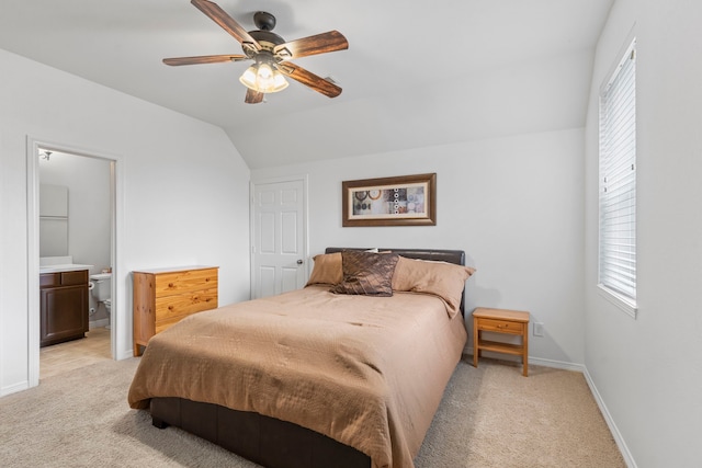 carpeted bedroom with connected bathroom, vaulted ceiling, and ceiling fan