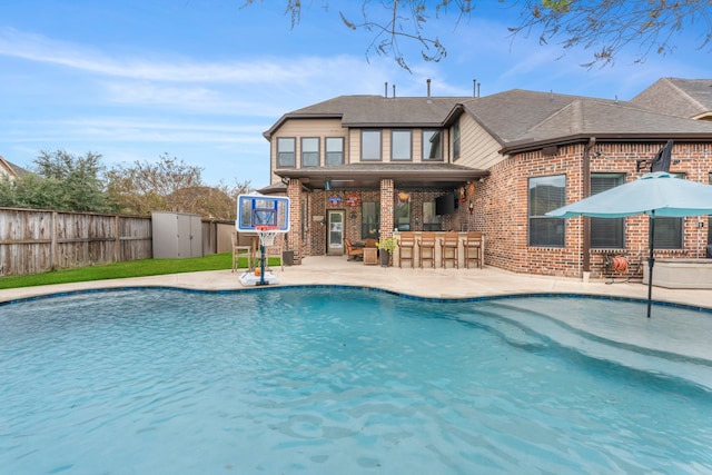 view of pool with a bar and a patio