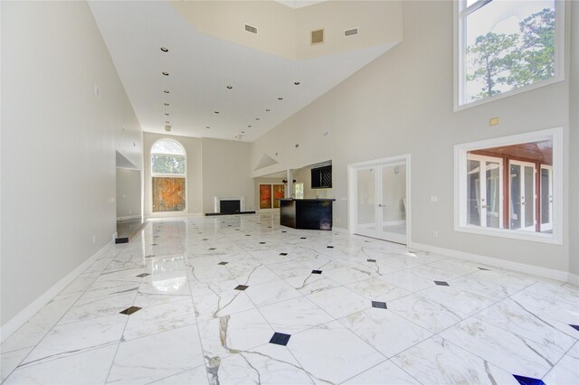 unfurnished living room with a high ceiling