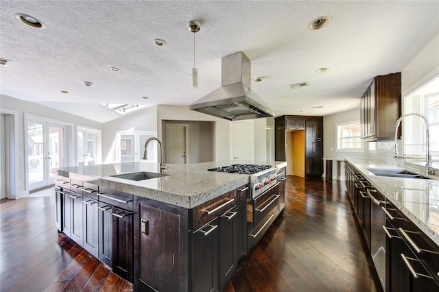 kitchen featuring sink, dark brown cabinetry, island exhaust hood, and a kitchen island with sink