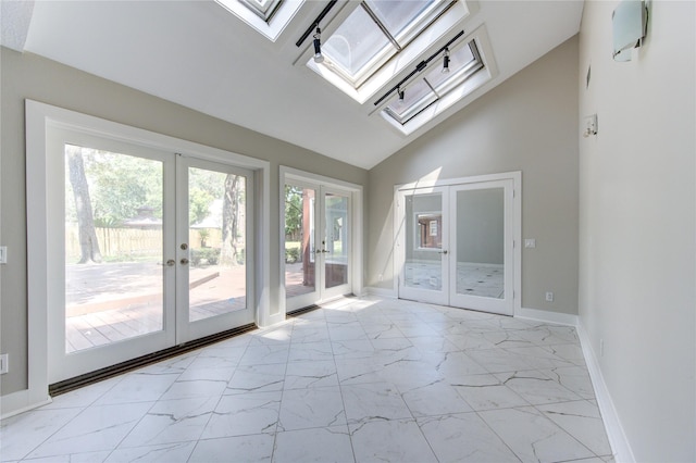 entryway featuring french doors, a skylight, and high vaulted ceiling