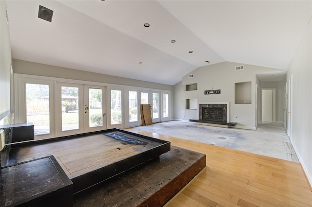 living room featuring french doors, lofted ceiling, and hardwood / wood-style floors