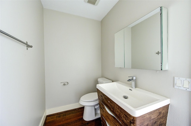 bathroom with hardwood / wood-style floors, vanity, and toilet