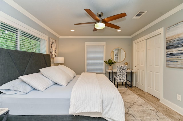 bedroom featuring ceiling fan, a closet, light hardwood / wood-style floors, and ornamental molding