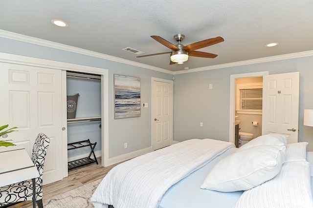 bedroom with crown molding, ceiling fan, light wood-type flooring, connected bathroom, and a closet