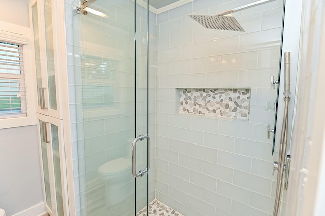 bathroom featuring toilet, walk in shower, and ornamental molding