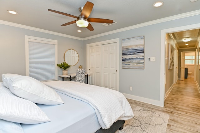 bedroom with light wood-type flooring, a closet, ceiling fan, and crown molding