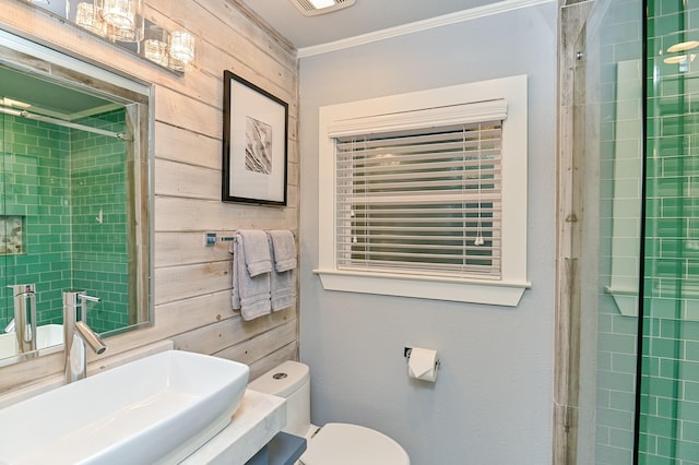 bathroom with toilet, crown molding, sink, and wooden walls