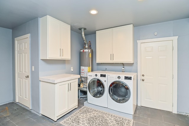 laundry room featuring cabinets, tile patterned flooring, washing machine and clothes dryer, and water heater