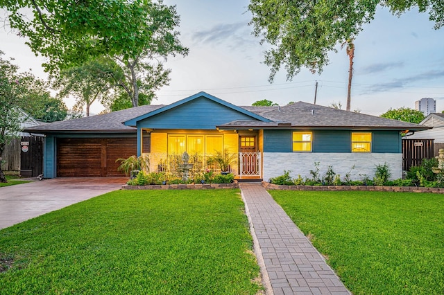 ranch-style home with a garage and a front lawn