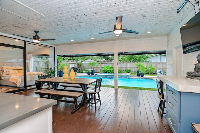 interior space featuring a bar, a fenced in pool, and ceiling fan