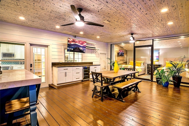 dining space with wine cooler, wooden walls, ceiling fan, and wood ceiling