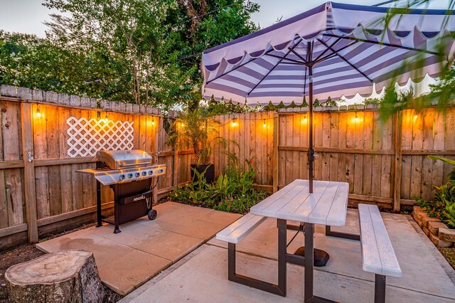 patio terrace at dusk featuring area for grilling