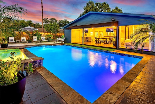 pool at dusk with a patio