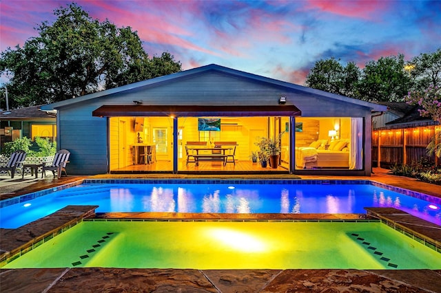 pool at dusk featuring a patio