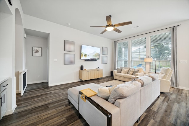 living room featuring ceiling fan and dark hardwood / wood-style floors