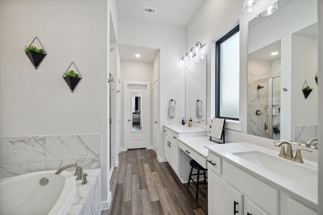 bathroom with shower with separate bathtub, vanity, and hardwood / wood-style flooring