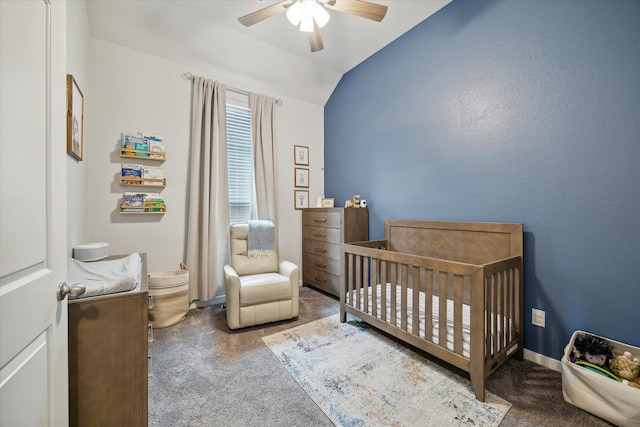 carpeted bedroom with ceiling fan, lofted ceiling, and a nursery area