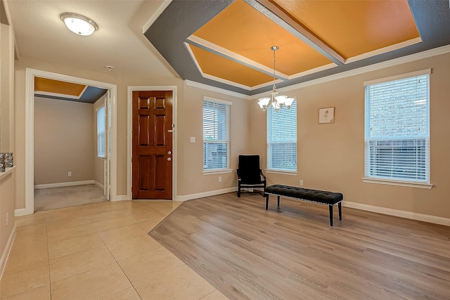 foyer entrance featuring a chandelier, ornamental molding, and light tile patterned flooring