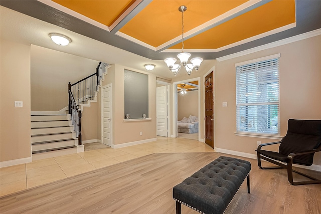 sitting room with ceiling fan with notable chandelier, light hardwood / wood-style floors, and ornamental molding