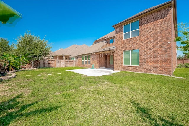 rear view of property featuring a lawn and a patio area