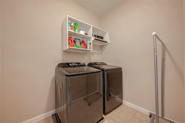 laundry room featuring washer and dryer and light tile patterned flooring