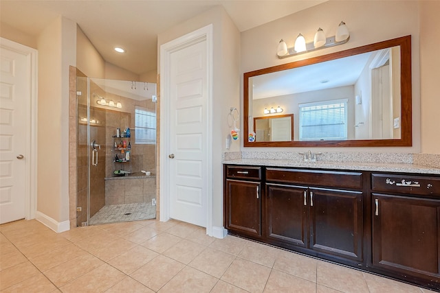 bathroom with tile patterned floors, vanity, and walk in shower