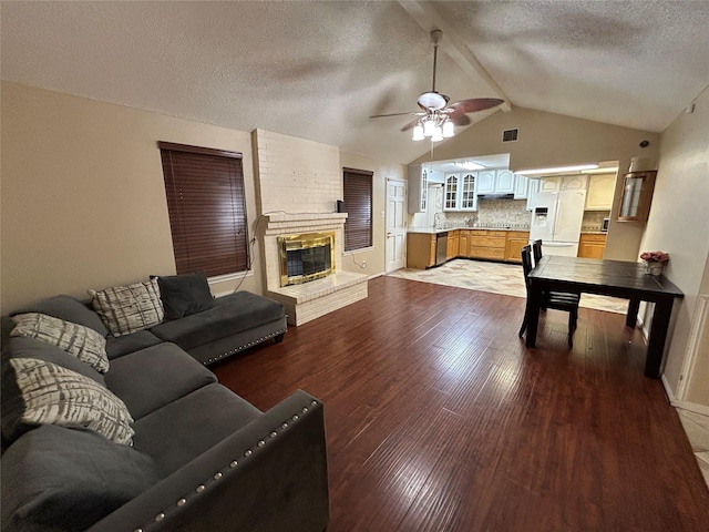 living room with lofted ceiling, sink, ceiling fan, a fireplace, and light hardwood / wood-style floors