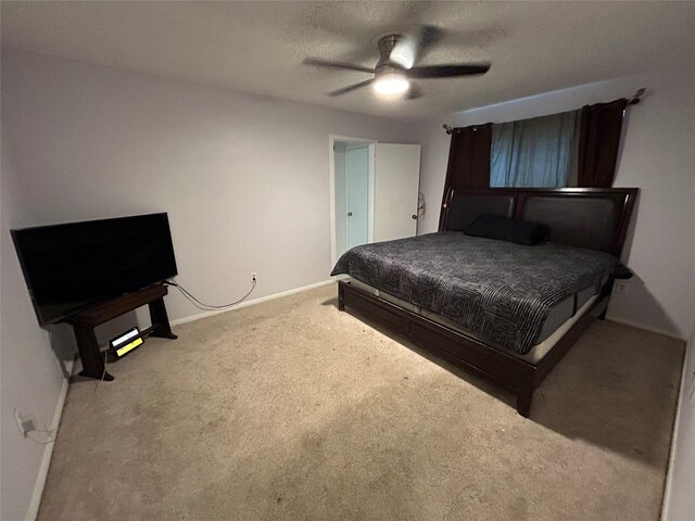 carpeted bedroom featuring ceiling fan and a textured ceiling