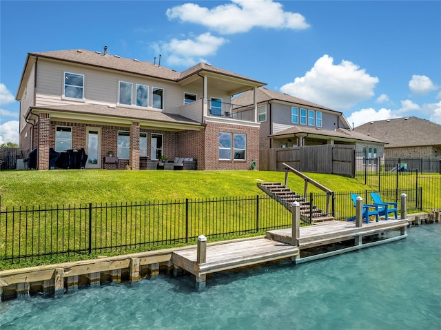 rear view of property featuring a yard and a balcony